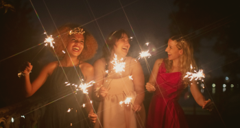 mujeres celebrando con bengalas en las manos y sonriendo